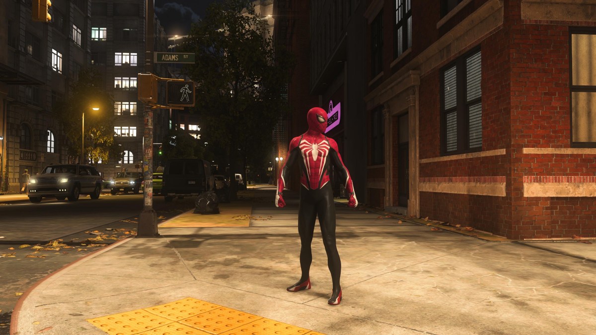 An image showing Peter Parker standing on a sidewalk in New York City in Marvel's Spider-Man 2 as part of a guide on how to unlock all the suits for him in the game.