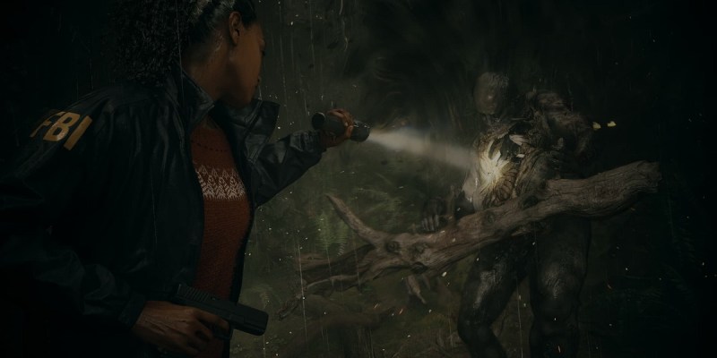 Image of Saga using flashlight and revolver to defeat monster in Alan Wake 2.