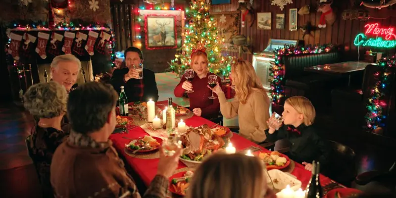 Characters sitting and having a Christmas meal. This image is part of an article about when Virgin River Season 6 comes out.