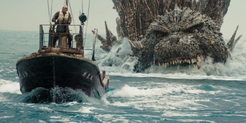 A boat being chased by Godzilla, a giant lizard monster.
