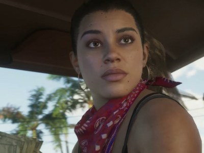 A women in a car, turning around to face the back seat, with a bandana round her neck. This image is part of an article about who voices Lucia in GTA 6.