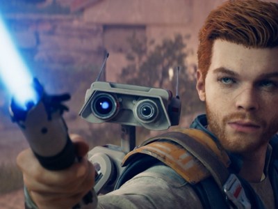 Image of red-haired man with a small robot on his back holding up a blue lightsaber.