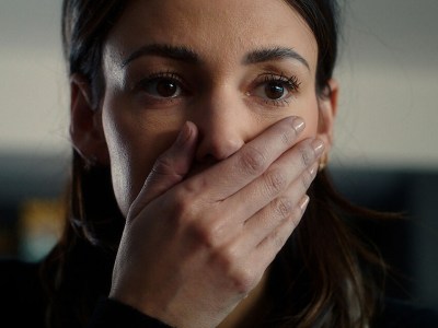A woman with her hand held over her mouth. This image is part of an article about Netflix's Fool Me Once's ending, explained.