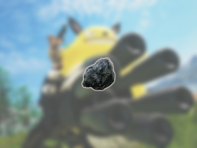 An image of the coal resource in Palworld against a blurred backdrop showing one of the Pals with a gatling gun.