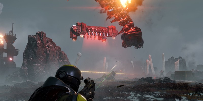 A man in a sci-fi set of armour shootingaway as two space-ships crash in front of him. This image is part of an article about how Helldivers 2 is fun but struggles to push beyond that.