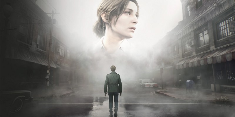 An image of the Silent Hill 2 remake, with a man in a green jacket standing in a town looking at a ghostly image of a giant woman's head.