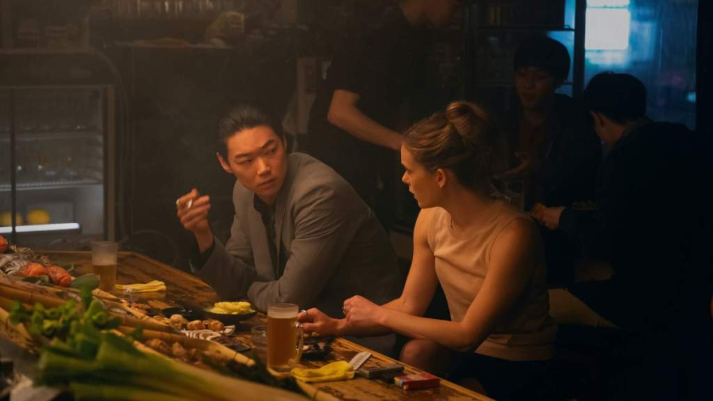 Sato and Samantha at a restaurant. This image is part of an article about the best shows like True Detective.